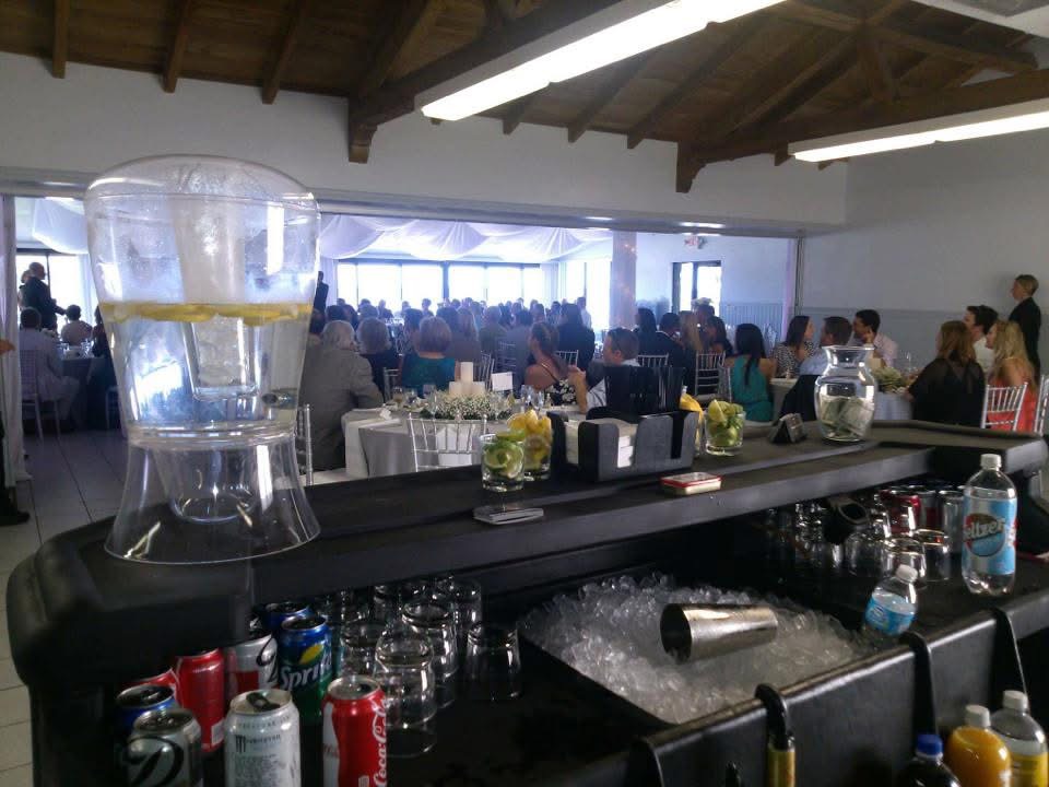 Portable bar set up in front of a full wedding reception